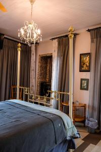 una camera da letto con un letto e un lampadario a braccio di Art Gallery Guest House a Haenertsburg