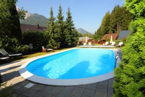 una grande piscina blu in un cortile di Vila Edelweiss Rooms&App Kranjska Gora a Kranjska Gora