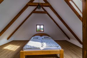 a bedroom with a bed in the attic at Tagyon Birtok Kései szüret Apartmanház in Tagyon