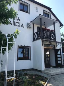 um edifício branco com uma varanda e janelas em Villa Galicia em Berehove