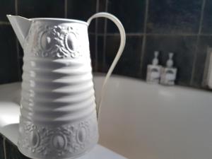 a white vase sitting on a counter next to a bath tub at 440@Brooklyn in Pretoria +70 photos