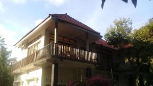 a large white house with a balcony at Kri Homestay in Kuta Lombok