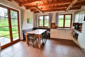 eine Küche mit einem Holztisch und einigen Fenstern in der Unterkunft Apartmány Maršíkov in Velké Losiny