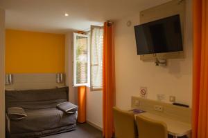 Habitación con cama y TV en la pared. en Hôtel de Paris La Défense en Puteaux