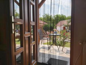 an open door to a patio with a table and chairs at Bornemisza Kuria in Tiszabecs