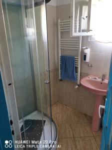 a bathroom with a glass shower and a sink at Enjoy Hostel in Cluj-Napoca