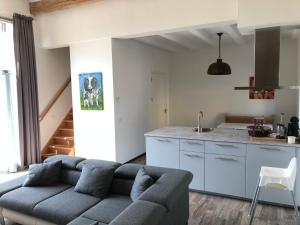 a living room with a couch and a kitchen at De Schuur in Walem