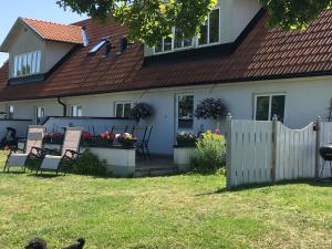 uma casa com cadeiras e uma cerca no quintal em Statarlängan em Visby
