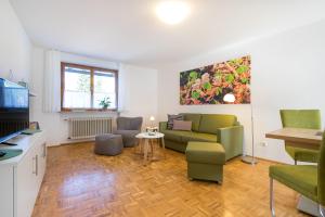 uma sala de estar com um sofá e uma mesa em Ferienwohnungen Alpentraum - Landhaus Eberle em Oberstdorf