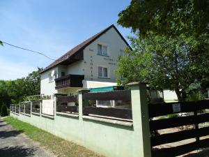 a white building with a fence in front of it at szt.flórián in Cserszegtomaj