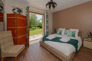 um quarto com uma cama grande e uma janela em Le Clos Magedon em Médan