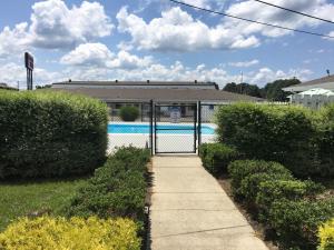 a swimming pool with a gate in a yard at Ambassador Inn in Manchester