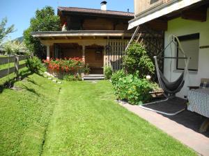 una casa con un patio verde con una hamaca en Haus Schatzbergblick, en Oberau