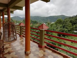 a balcony of a resort with a view of the mountains at Panthalams Homestay in Thekkady