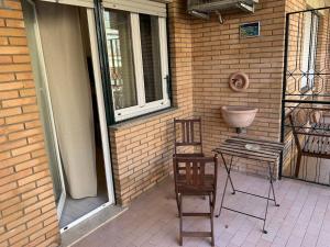 d'une terrasse avec 2 chaises, une table et une fenêtre. dans l'établissement Tiburtina Suites, Roma, à Rome