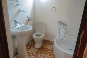 un bagno bianco con lavandino e WC di Kutaisi Center Guesthouse a Kutaisi