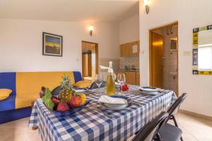 a table with a bowl of fruit on a blue and white table cloth at Fisa Apartments in Vir +26 photos