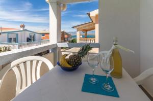 a table with two wine glasses and a bowl of fruit at Fisa Apartments in Vir