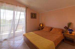 a bedroom with a bed and a large window at Fisa Apartments in Vir