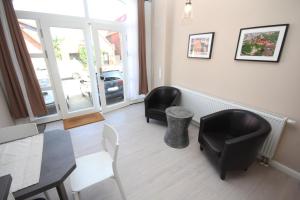 a living room with two black chairs and a table and a table and chairsktop at Kalkberg Ferienwohnungen in Bad Segeberg