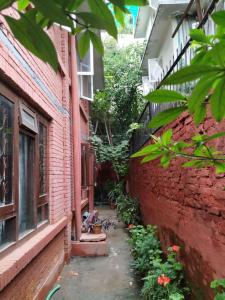 un callejón entre un edificio de ladrillo con flores y plantas en Family Peace House, Kathmandu, en Katmandú