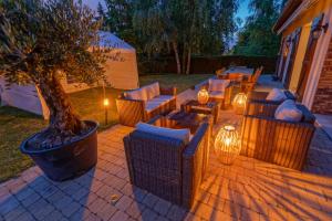 une terrasse avec des canapés, un arbre et des lumières dans l'établissement Le Clos Magedon, à Médan