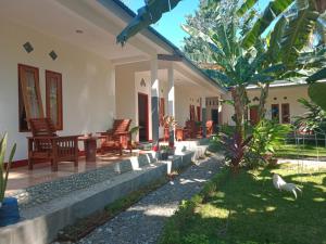 un patio de una casa con sillas y árboles en Riung Guesthouse, en Riung