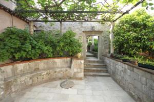 einen Außengang mit einer Pergola und eine Treppe mit Pflanzen in der Unterkunft Old Town Garden Apartments in Dubrovnik