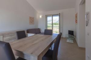 comedor con mesa de madera y sillas en Nebrodi Park Private Villa, en SantʼAgata di Militello