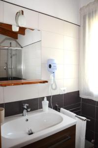 a bathroom with a sink and a hair dryer on the wall at B&B Il Mirto di Paola in Torpè