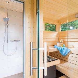 una sauna con ducha y una puerta de cristal en Haus Sternengucker en Sankt Peter-Ording