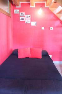 um quarto com uma parede rosa e uma cama em Simonshome em Sarre-Union