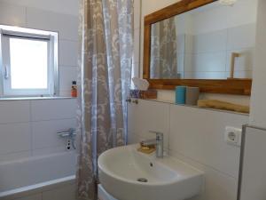 ein Badezimmer mit einem Waschbecken, einem Spiegel und einer Badewanne in der Unterkunft Ferienwohnung Gretl & Xaver in Neumarkt in der Oberpfalz