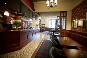 a bar with tables and chairs in a restaurant at Gwesty Links in Llandudno