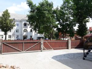 uma cerca em frente a uma casa com uma carrinha atrás dela em Centras em Kėdainiai