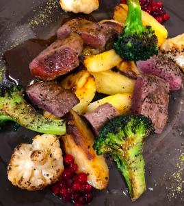 a plate of food with meat and vegetables and broccoli at Tysfjord Hotel in Storjord I Tysfjord
