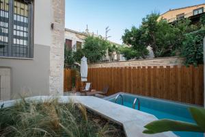 un patio trasero con piscina y una valla de madera en Casa Vitae Villas, en Rethymno