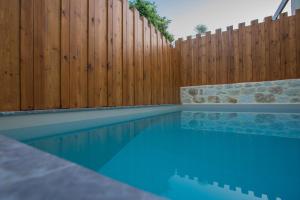 a swimming pool in front of a wooden fence at Casa Vitae Villas in Rethymno