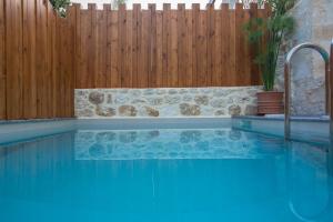 a swimming pool in front of a wooden fence at Casa Vitae Villas in Rethymno