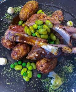 a plate of food with meat and potatoes and peas at Tysfjord Hotel in Storjord I Tysfjord