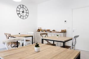ein Zimmer mit Tischen und Stühlen und einer Uhr an der Wand in der Unterkunft Li Cetti in Lecce