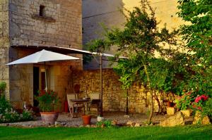 un patio con mesa y sombrilla en Villa Mas, en Cestayrols