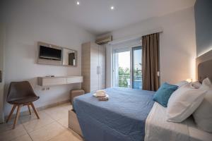 a bedroom with a large bed and a balcony at Stegna Bay Apartment in Archangelos