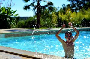 un niño está en una piscina en Villa Mas, en Cestayrols