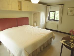 1 dormitorio con cama blanca y ventana en At Last Bed & Breakfast en Edlington