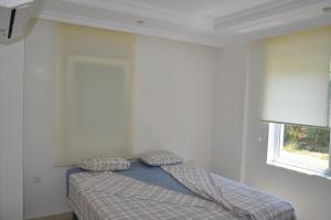 a bed in a white room with a window at Orion Valley Home in Avsallar