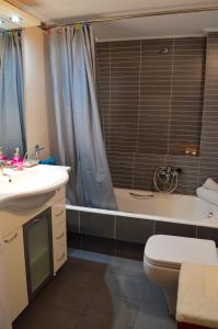 a bathroom with a tub and a toilet and a sink at Acropolis in Athens