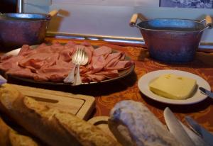 una tavola con un piatto di cibo con forchetta e formaggio di Hôtel Bella Tola & SPA a Saint-Luc