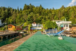 a couple of chairs sitting on a dock next to the water at Seelacherhof in Sankt Kanzian