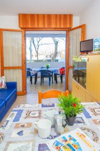 ein Wohnzimmer mit einem Tisch und einem blauen Sofa in der Unterkunft Villa Patrick in Bibione